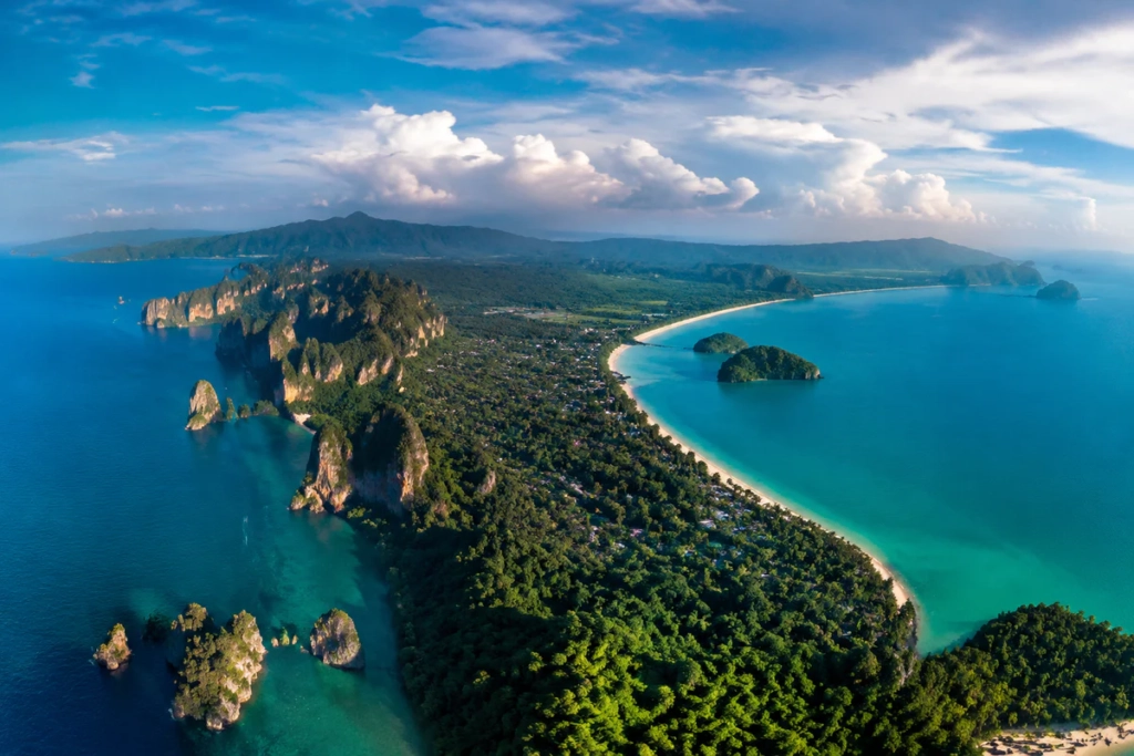 Vue aérienne panoramique des deux façades maritimes de la Thaïlande, entre falaises calcaires, îles tropicales, plages de sab
